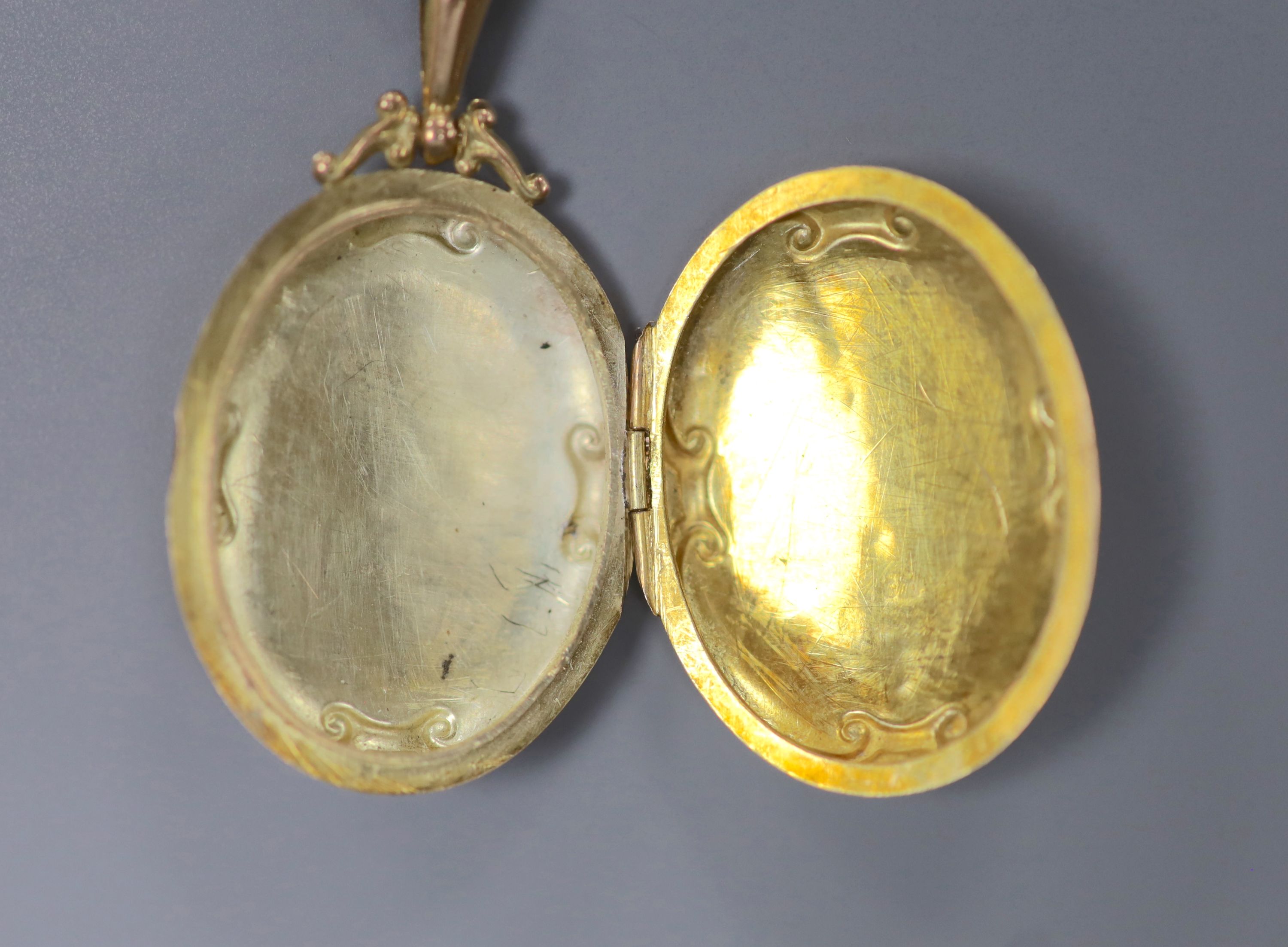 An Edwardian Art Nouveau 9ct gold oval locket, on a 9ct chain